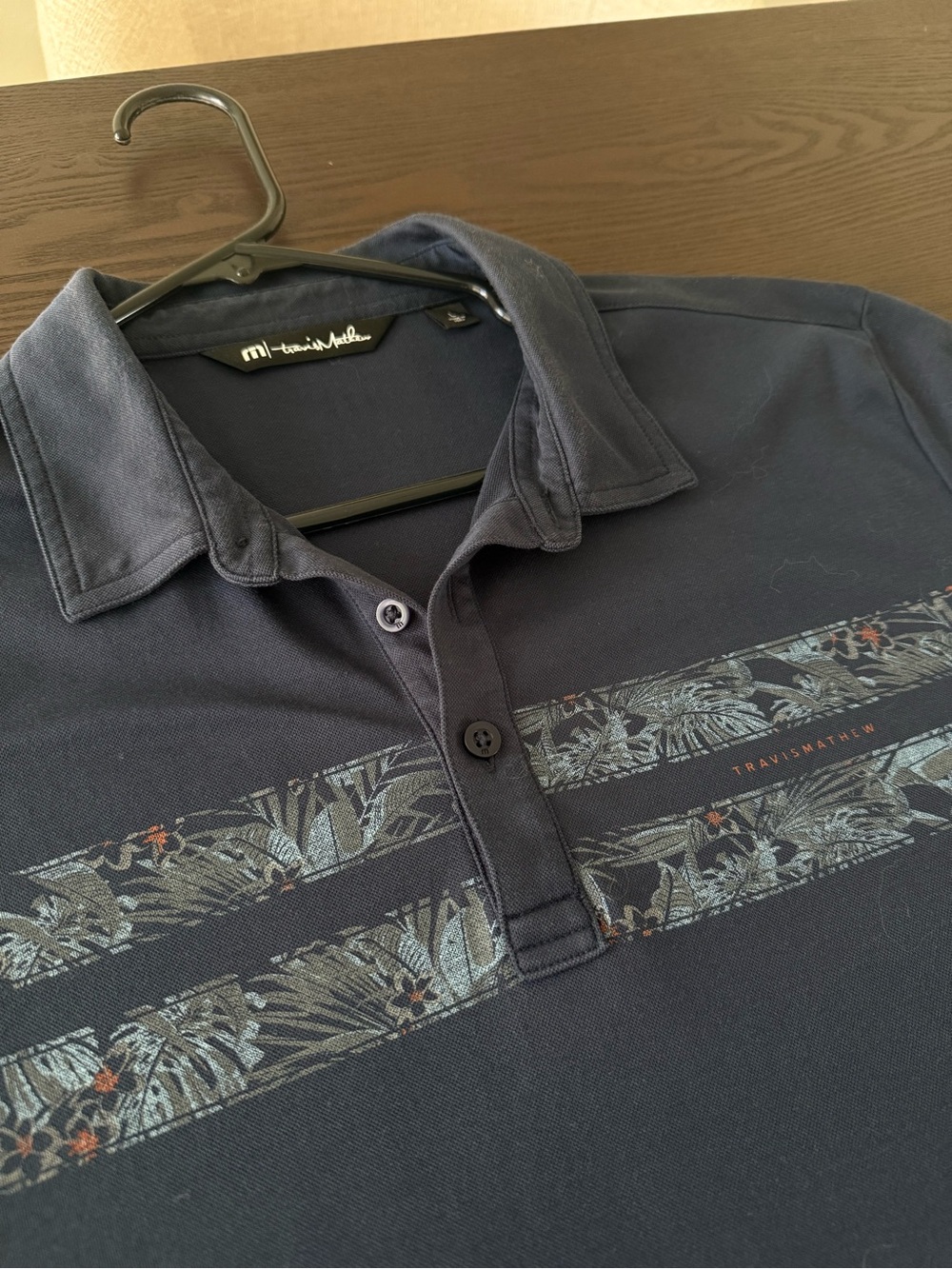 Travis Mathew Navy Polo with Subtle Tropical Stripe Accents